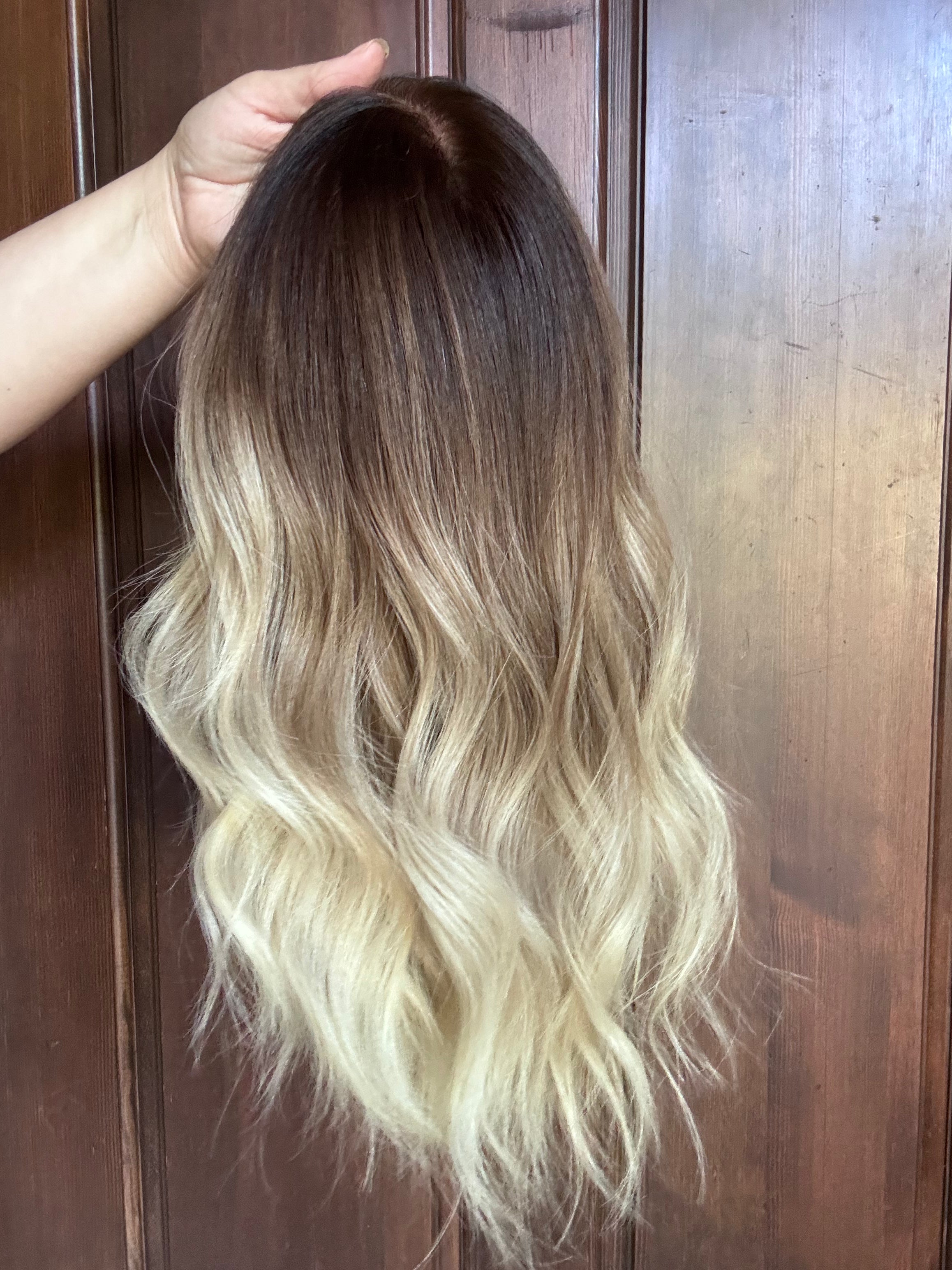 Holding out a medium length human hair wig